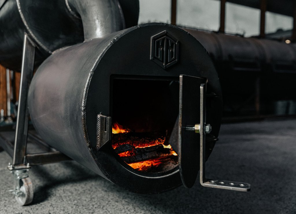 Fire burning in the firebox of a Goldee's backyard offset smoker