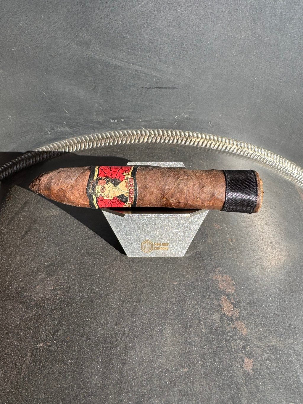 Cigar resting on the stainless M&M wallet cigar holder