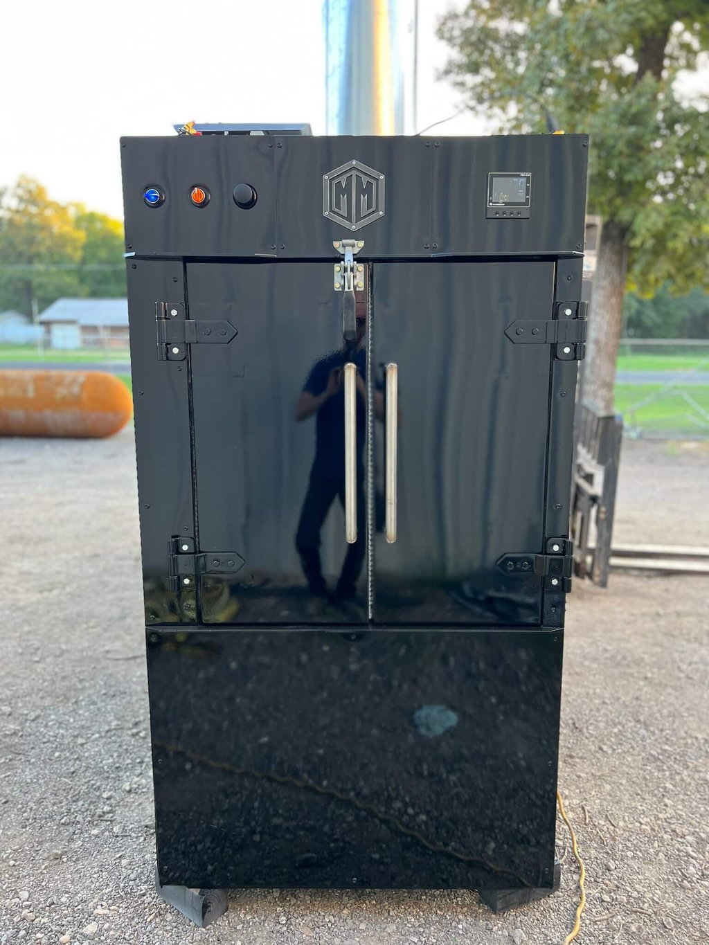 Black MM240 rotisserie smoker, front view with the M&M badge