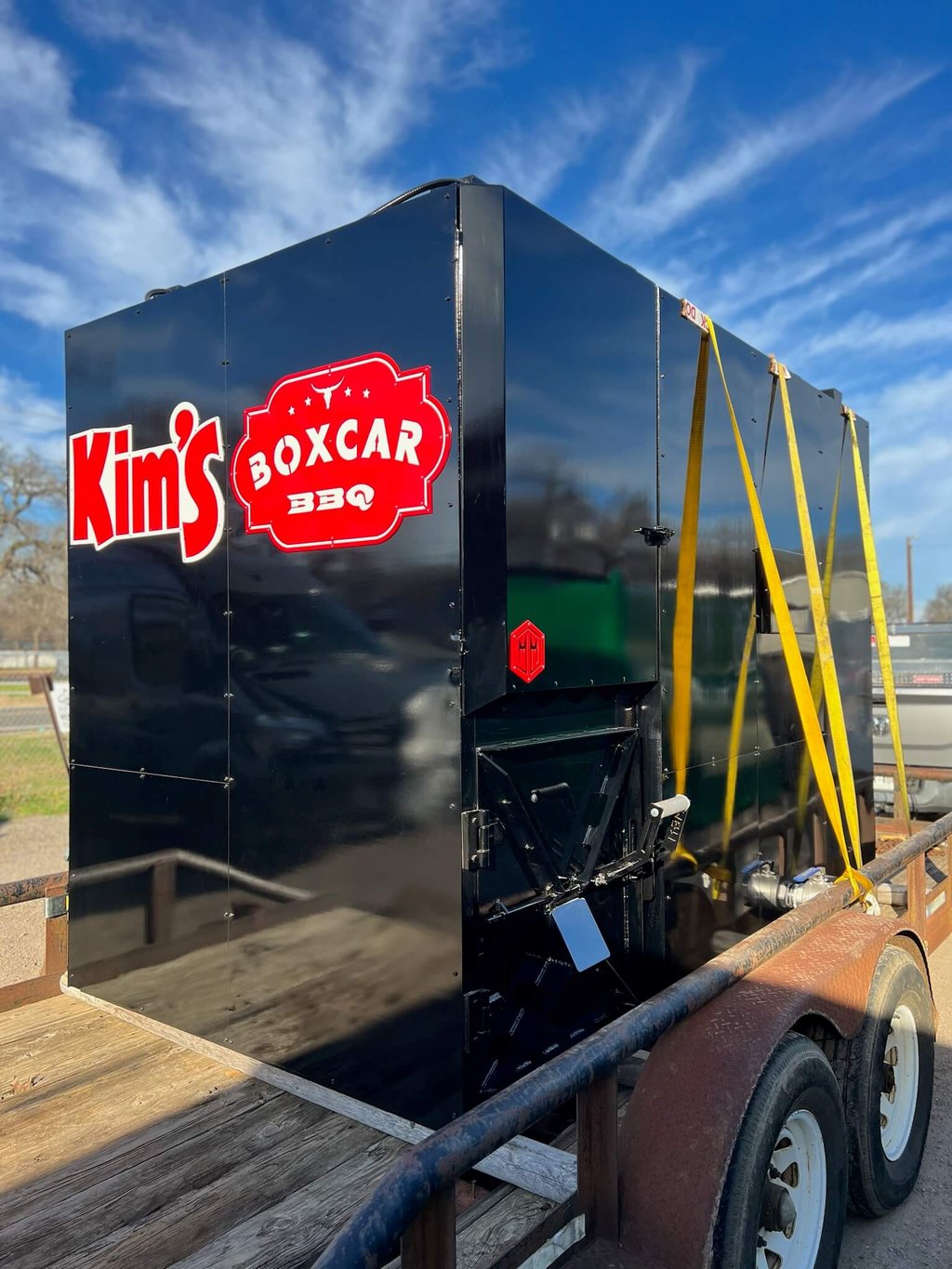 Rotisserie smoker built for Kim's Boxcar BBQ, strapped to a trailer