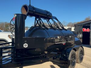 Black 500 gallon offset built into a trailer with double El Nino woodfire grill